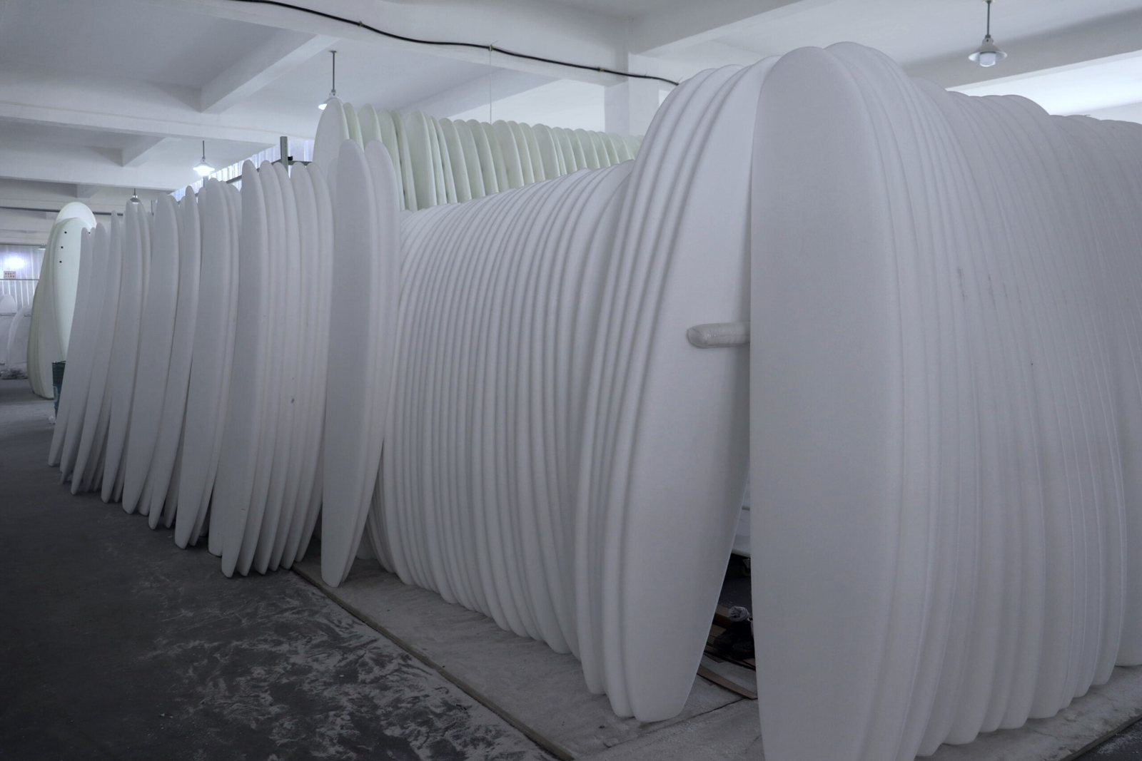 Rows of foam surfboard blanks waiting for shaping in our Cixi factory