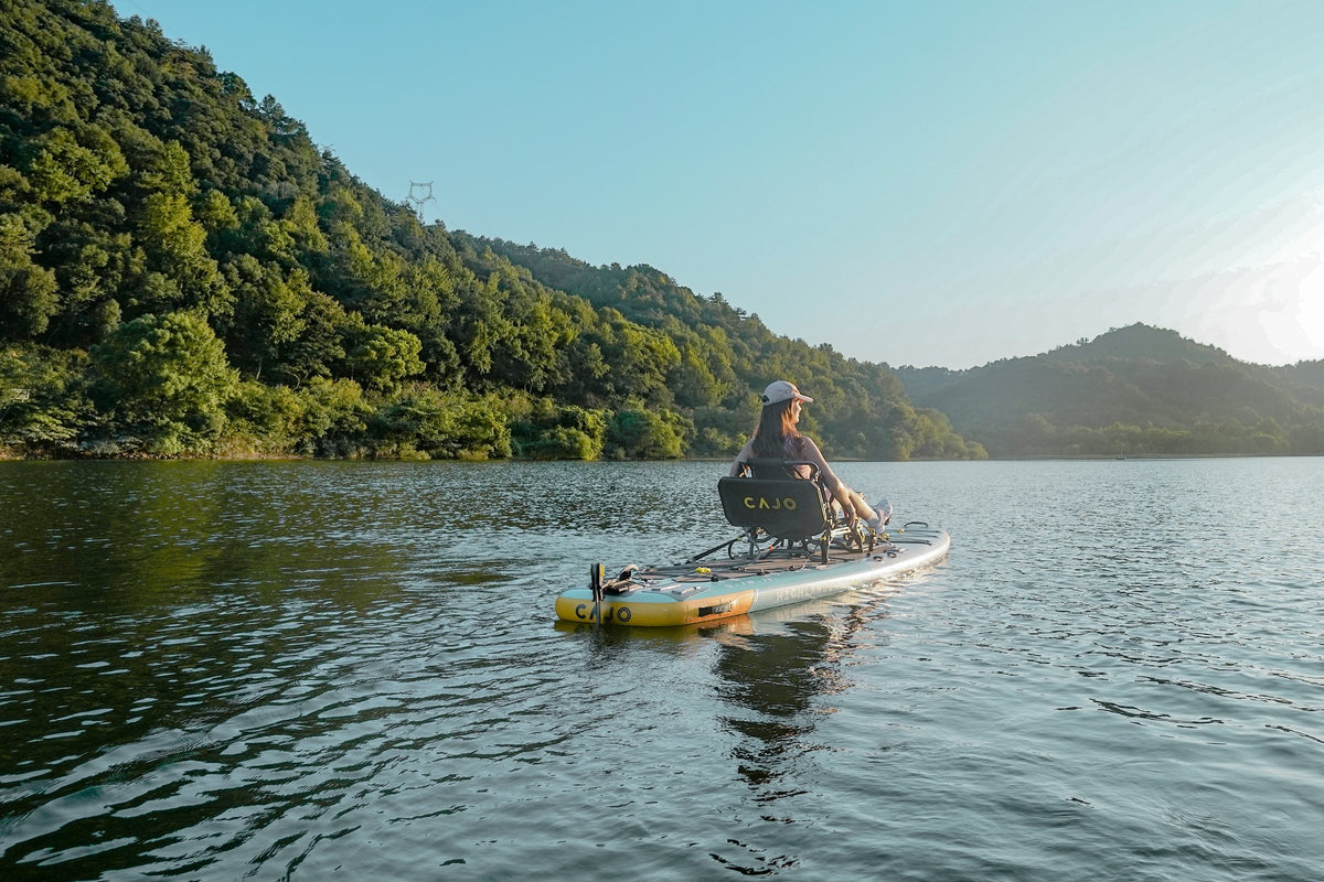 A paddler on a pedal board on a mountain lake at sunrise
